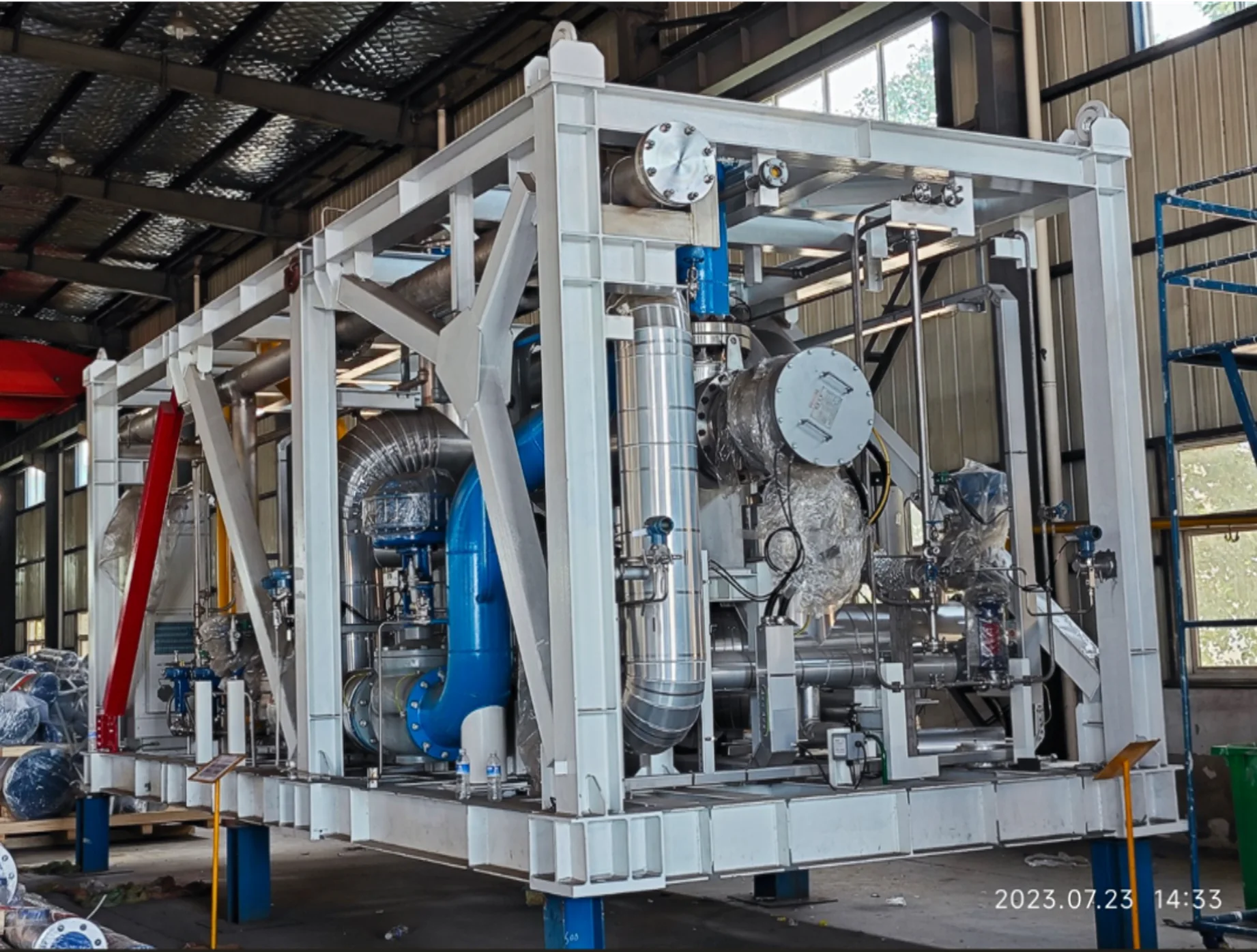 Vessel and piping mounted inside a white structural frame